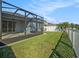 Backyard features a screened-in patio, lawn and a tall privacy fence, ideal for relaxation and outdoor activities at 13192 Royal Pines Ave, Riverview, FL 33579