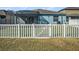 A property's backyard includes a screened-in patio, grassy area, and white privacy fence for secure outdoor living at 13192 Royal Pines Ave, Riverview, FL 33579