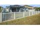 Well maintained backyard shows a screened-in patio, lawn, and a white privacy fence, creating a great outdoor space at 13192 Royal Pines Ave, Riverview, FL 33579
