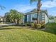 Landscaped front yard with green grass, blue siding, and white trim accents on this well-maintained single Gathering home at 13192 Royal Pines Ave, Riverview, FL 33579