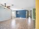 Spacious living room with tile flooring, ceiling fan, and view of the home's entrance, creating a welcoming atmosphere at 13192 Royal Pines Ave, Riverview, FL 33579