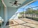 A covered and screened-in patio area featuring a ceiling fan, neutral pavers, and views of the grassy yard at 13192 Royal Pines Ave, Riverview, FL 33579