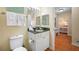 A well-lit bathroom, granite countertop, with an adjacent bedroom space viewed through the doorway at 13235 Gulf Blvd # 306, Madeira Beach, FL 33708
