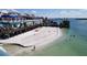 Picturesque beach scene with a sandy shoreline, clear water, and waterfront establishments at 13235 Gulf Blvd # 306, Madeira Beach, FL 33708