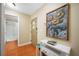 Hallway with decorative artwork, a console table, and tile flooring, leading to the bathroom at 13235 Gulf Blvd # 306, Madeira Beach, FL 33708