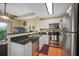 Galley kitchen featuring stainless steel appliances, white cabinets, and granite countertops at 13235 Gulf Blvd # 306, Madeira Beach, FL 33708