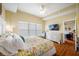 Spacious bedroom with a large floral bed, white dresser, TV, and an adjacent bathroom, offering a tranquil retreat at 13235 Gulf Blvd # 306, Madeira Beach, FL 33708