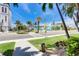 Neighborhood street view with crosswalk, palm trees, and colorful buildings in a vibrant coastal setting at 13235 Gulf Blvd # 306, Madeira Beach, FL 33708