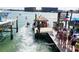 Lively waterfront scene with jet skis, a tiki bar, and people enjoying water activities at 13235 Gulf Blvd # 306, Madeira Beach, FL 33708