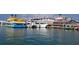Scenic waterfront view of docked fishing boats and colorful buildings in a vibrant coastal area at 13235 Gulf Blvd # 306, Madeira Beach, FL 33708