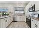 Modern kitchen with white cabinets, granite countertops, and stainless steel appliances at 1446 Jumana Loop, Apollo Beach, FL 33572