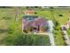 Aerial view of beautiful home with pool, screened enclosure, and surrounding green lawn at 14739 Vista View Ct, Dade City, FL 33523