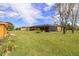 The backyard features a large, well-maintained lawn, mature trees, and a screened lanai at 14739 Vista View Ct, Dade City, FL 33523