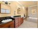 Bright bathroom with double vanity, granite counters, soaking tub, and tile flooring for a luxurious feel at 14739 Vista View Ct, Dade City, FL 33523