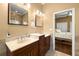 Bathroom featuring double sinks, decorative tile flooring, wooden cabinets, and views into the bedroom at 14739 Vista View Ct, Dade City, FL 33523