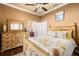 Bedroom with decorative bedside table, en suite bathroom access, and ceiling fan at 14739 Vista View Ct, Dade City, FL 33523