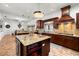 Spacious kitchen with granite counters, center island, modern lighting, and dark wood cabinets at 14739 Vista View Ct, Dade City, FL 33523