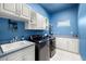 Well-organized laundry room with modern appliances, ample counter space, and blue painted walls at 14739 Vista View Ct, Dade City, FL 33523