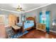 Comfortable main bedroom with hardwood floors, coastal decor, ceiling fan, and warm natural light at 14739 Vista View Ct, Dade City, FL 33523