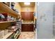 Pantry with wooden shelves and cabinets for ample storage, frosted pantry door, and tiled floors at 14739 Vista View Ct, Dade City, FL 33523