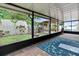 Enclosed patio area with brick flooring, a view of the backyard and pool at 1560 Bel Keene Dr, Clearwater, FL 33756