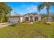 Charming single-story home with a well-manicured lawn, inviting front porch, and attached two car garage at 1746 Golden Dawn Pl, Wesley Chapel, FL 33543