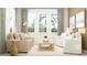 Light and airy living room featuring a comfy beige sofa and large windows at 18429 Serene Lake Loop, Lutz, FL 33548