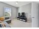 Bedroom featuring a sleek TV with modern stand, complemented by a gray sofa and a view from the window at 1896 Tallulah Ter, Wesley Chapel, FL 33543