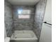 Renovated bathroom offers tub with tiled surround and window for natural light at 2036 Melody Dr, Holiday, FL 34691