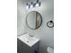 Bathroom showcases a vanity with cabinet storage, sink, mirror, and lighting at 2036 Melody Dr, Holiday, FL 34691