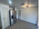 Well lit dining room featuring wood-look flooring, a modern light fixture and stainless-steel refrigerator at 2036 Melody Dr, Holiday, FL 34691