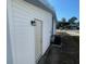 The home's side exterior with a back door is showcased with an attached AC unit at 2036 Melody Dr, Holiday, FL 34691