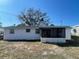 Exterior view of home with a screened in porch and a well maintained backyard at 2036 Melody Dr, Holiday, FL 34691
