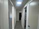 Hallway leading to rooms with wood-look floors and white walls at 2036 Melody Dr, Holiday, FL 34691