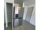 Large stainless-steel refrigerator adjacent to pantry with wire shelving at 2036 Melody Dr, Holiday, FL 34691