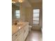 Bathroom featuring a vanity with white cabinets, tile flooring, and a framed mirror at 2051 High Ridge Dr, Clearwater, FL 33763