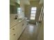 Bathroom featuring a vanity with white cabinets, tile flooring, and a framed mirror at 2051 High Ridge Dr, Clearwater, FL 33763