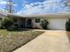 Inviting exterior view of a well-maintained single-story home with an attached garage and nice yard at 2051 High Ridge Dr, Clearwater, FL 33763