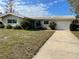 Charming single-story home with neutral paint, white tiled roof, and attached garage at 2051 High Ridge Dr, Clearwater, FL 33763