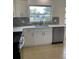 Stylish kitchen with white cabinets, stainless steel dishwasher, and modern fixtures at 2051 High Ridge Dr, Clearwater, FL 33763