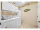 Laundry room with overhead cabinets and a washer and dryer at 2589 Northfield Ln, Clearwater, FL 33761