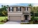 Two-story house with neutral siding, dark accents, and a two-car garage at 36084 Sunflower Hill Dr, Zephyrhills, FL 33541