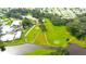 Aerial view of a well-manicured golf course with ponds, surrounding mature trees, and residential homes at 36852 Kimela Ave, Zephyrhills, FL 33542