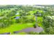 Aerial view of a lush golf course featuring ponds, mature trees, and manicured greens at 36852 Kimela Ave, Zephyrhills, FL 33542