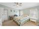 Cozy bedroom with light green walls, a bed with a patterned comforter, a desk, and natural lighting at 36852 Kimela Ave, Zephyrhills, FL 33542