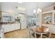 Spacious kitchen featuring white cabinets, a window, white appliances and adjacent dining area at 36852 Kimela Ave, Zephyrhills, FL 33542