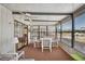 Enclosed sunroom with multiple windows, ceiling fan, and table with four chairs; ideal for relaxation and entertaining at 36852 Kimela Ave, Zephyrhills, FL 33542