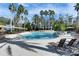 Resort-style pool area with lounge chairs, umbrellas, and lush tropical landscaping at 3852 Sorrel Vine Dr, Wesley Chapel, FL 33544