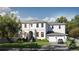 Two-story white home features a manicured lawn, trimmed hedges, a grey roof and a two car garage at 4614 W Tennyson Ave, Tampa, FL 33629