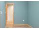 This bedroom features blue walls, a wooden door frame, and light hardwood floors at 4777 Duhme Rd # 1A, St Petersburg, FL 33708